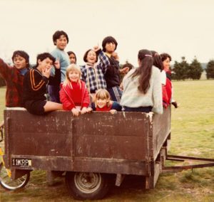 Jacinda as a young girl riding trailer with friends 