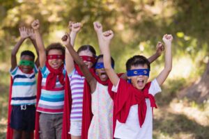 A group of children dressed up as super heroes in capes and masks