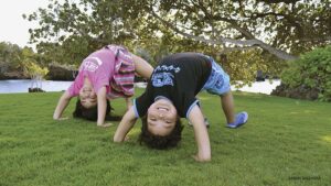 kids doing yoga outside on the grass 